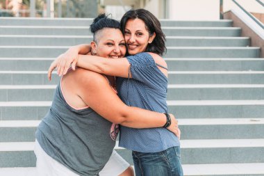 İki yetişkin ikiz kardeş sarılıyor. Farklı biçimler