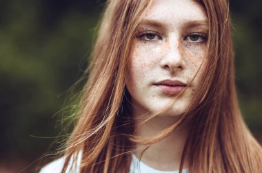 Kızıl saçlı genç kızın yakın plan portresi.