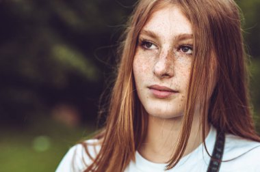 Kızıl saçlı genç kızın yakın plan portresi.