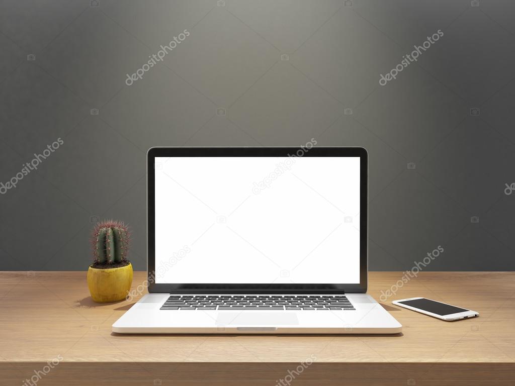 laptop and phone with blank screen on desk front gray wall