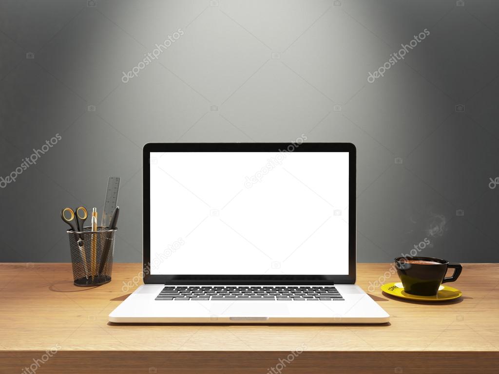 laptop and coffee with blank screen on desk front gray wall