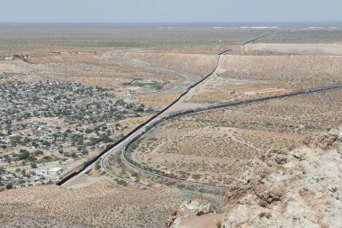 Sınır duvarı veya çit ve tren, New Mexico sınırın ABD tarafında yük trenine paralel gidiyor.
