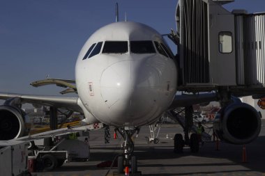 Terminal kapısındaki uçak günbatımında modern uluslararası havaalanından kalkmaya hazır.