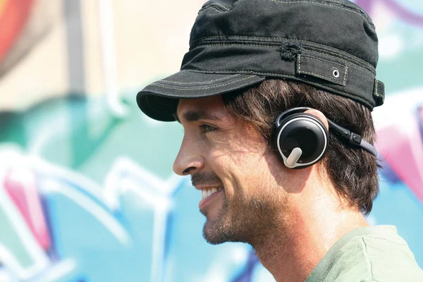 Cara ouvindo jogador em fones de ouvido e — Fotografia de Stock