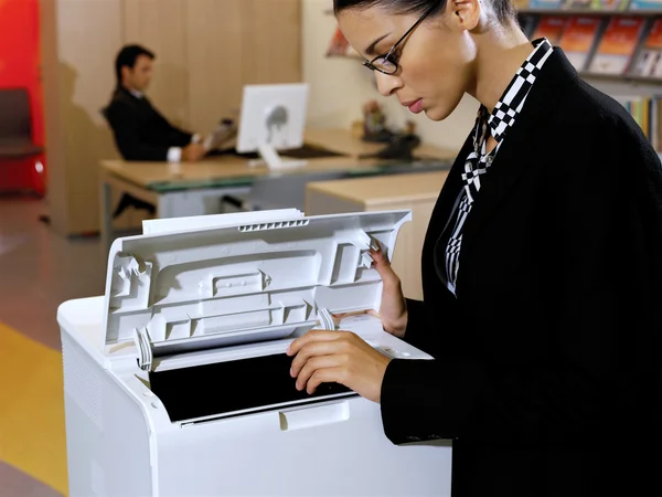 Businesswoman using copy machine — Stock Photo, Image