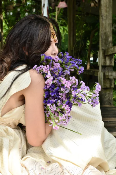 Hermosa mujer con ramo de flores sentado en un jardín y esperando a alguien —  Fotos de Stock