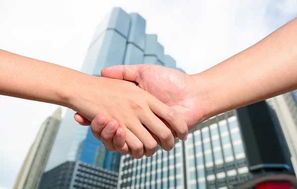 Main partenaire entre un homme et une femme sur fond de construction Images De Stock Libres De Droits