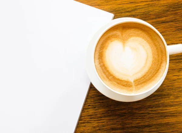 Ένα φλιτζάνι καφέ με σχήμα καρδιάς και ανοιχτό κενό βιβλίο — Φωτογραφία Αρχείου