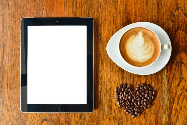 Digitaler Tablet-PC und eine Tasse Kaffee mit Herzform — Stockfoto