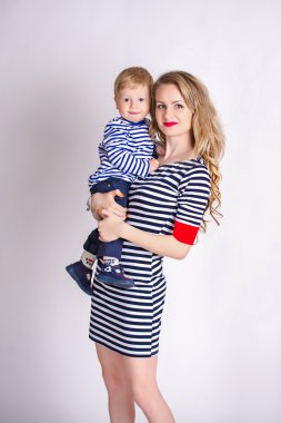 Mother with her son in her arms, blond, smiling, striped clothes, the family sailor