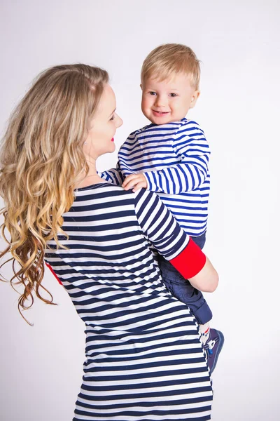 Mère avec son fils dans les bras, blonde, souriante, vêtements rayés, le marin de la famille — Photo