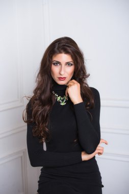 ileri arıyorum, arıyorum güzel gözleri, parlak makyaj, dumanlı gözler, genç esmer kadın beyaz bir arka plan, güzel, uzun boylu bir siyah beyaz elbise, kırmızı ruj, yüksek topuklar,