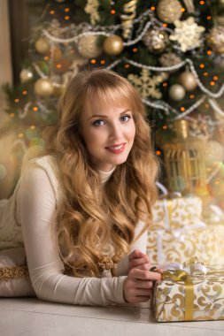 Genç güzel sarışın kız, kadın bir Noel ağacı, Noel ağacı, hediyeler, altın ağaç, altın rengi, mutlu kadın yeni yıl bir kız ile güzel bir odada