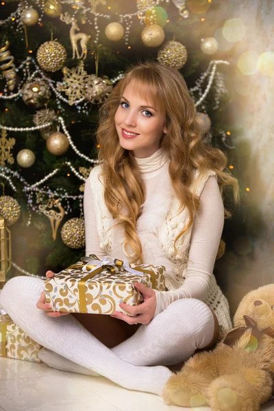 Młody piękny blond dziewczyna, kobieta w pięknej sali z Choinka, Choinka, dziewczyna z prezenty, drzewo złota, złote włosy, kobieta szczęśliwego nowego roku — Zdjęcie stockowe