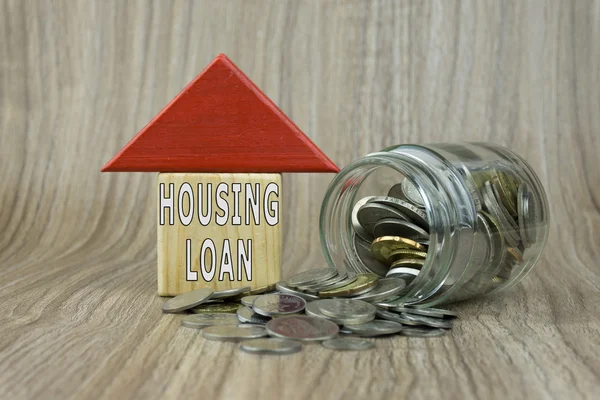 House Wooden Block with coins on a wooden background. Housing Loan concept. Selective focus