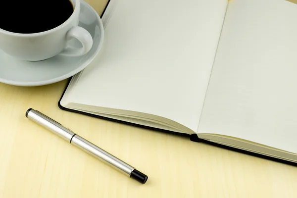 Tavolo da ufficio con penna, blocco note, tazza di caffè. Vista dall'alto Fotografia Stock