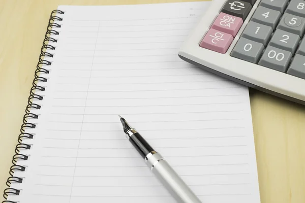 Bloc-notes vide sur la table de bureau avec stylo et calculatrice. Vue d'en haut — Photo