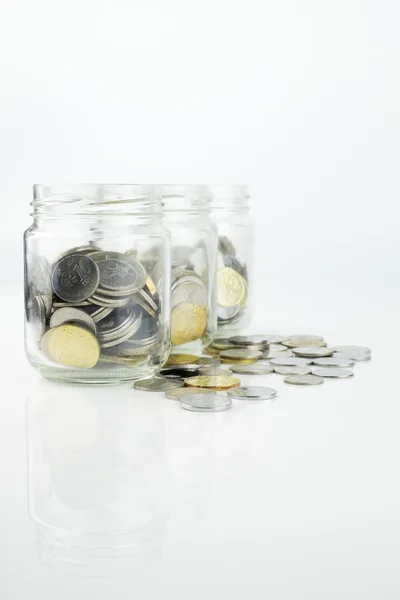 Vaso con monete. Focus selettivo su sfondo bianco — Foto Stock