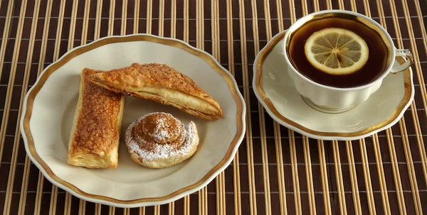 Pasteles de hojaldre y té con limón — Foto de Stock