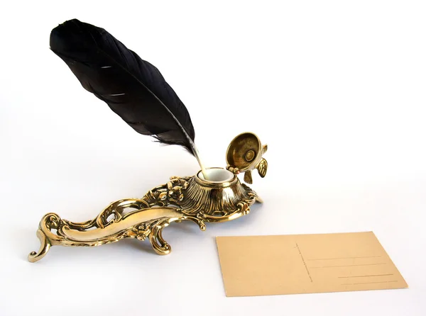 Латунная чернильница с перьями и открыткой — стоковое фото
