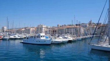 MARSEILLE, FRANCE 31 Mayıs 2021: Marsilya 'nın eski limanı (Vieux Limanı), yanından geçen ve içinde hiç insan olmayan çok sayıda yatı filme alan, pitoresk şehir manzarası, ünlü turizm beldesi