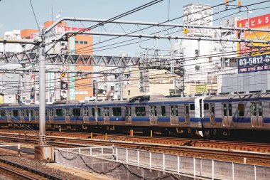 Tokyo, Japonya - 7 Nisan 2019. Tokyo, Japonya 'daki tren istasyonunda raylarda giden bir tren. Demiryolları Japonya 'da en önemli yolcu taşımacılığıdır..
