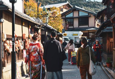 Kyoto, Japonya - 22 Kasım 2019. Japonya 'nın Kyoto şehrinde kimono giyen insanlar yürüyor. Kyoto, Japonya 'nın kültürel başkenti ve önemli bir turizm merkezi olarak kabul edilir..