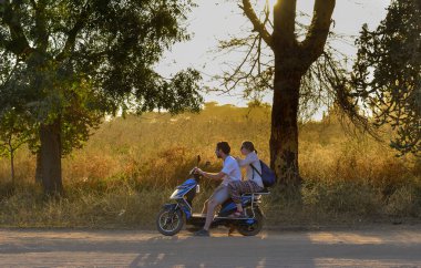Bagan, Myanmar - 4 Şubat 2017. Turistler Myanmar, Bagan 'da öğleden sonra tozlu bir yolda elektrikli bisiklete biniyorlar..
