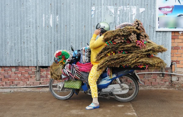 Büyük parsel bir motosiklet üzerinde taşıyan kadın