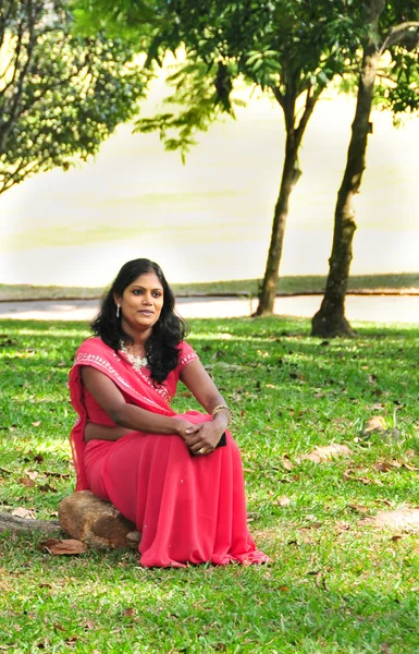 หญิงชาวศรีลังกา นั่งอยู่ที่สวนพฤกษศาสตร์คันดี้ — ภาพถ่ายสต็อก