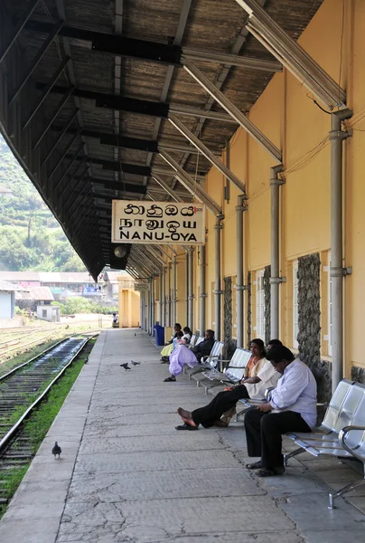 As pessoas esperam por um trem na plataforma ferroviária — Fotografia de Stock
