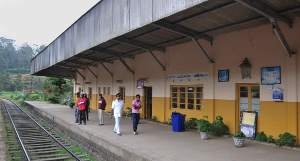 La gente espera un tren en la plataforma ferroviaria — Foto de Stock