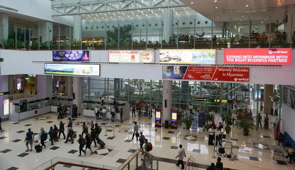 Los viajeros caminan en la terminal de pasajeros en el aeropuerto de Yangon — Foto de Stock