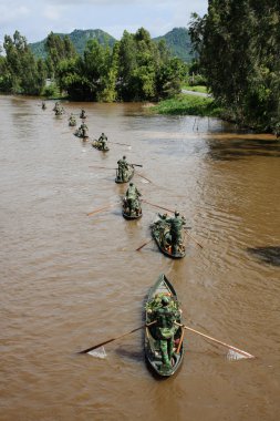 Vietnamlı askerler kürekli tekneler kanaldaki