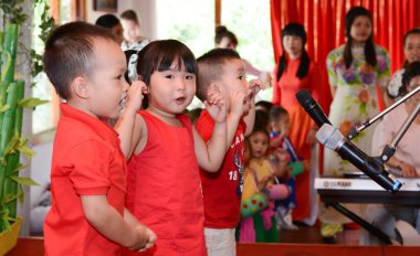 Mikrofonla sahnede şarkı çocuklar