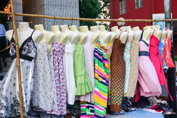 Vestidos de mujer colgando en exhibición en un mercadillo — Foto de Stock