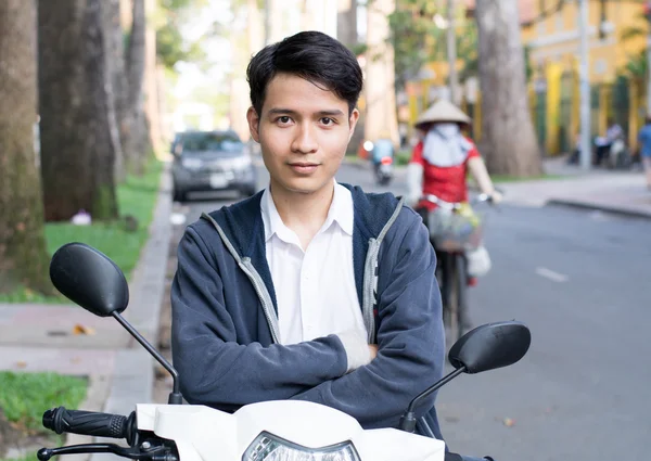 Asiático hombre con una motocicleta en la calle —  Fotos de Stock