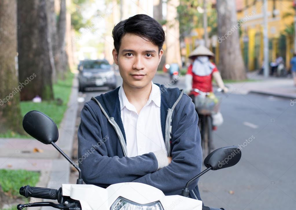 Asian man with a motorcycle on the street