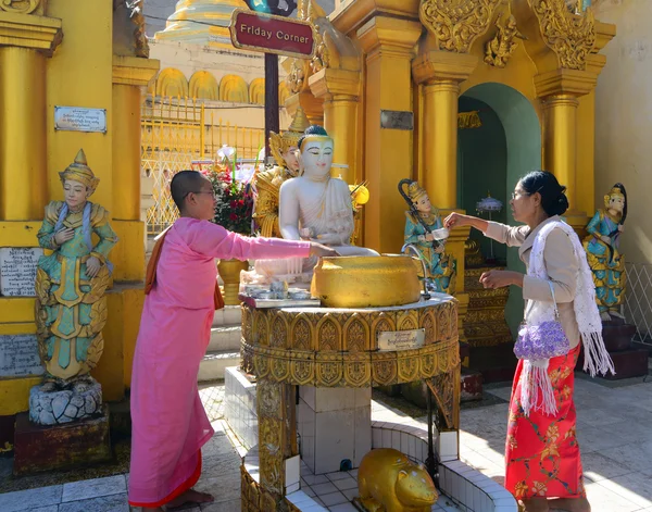 Devotos budistas bañan estatuas de Buda en la pagoda Shwedagon —  Fotos de Stock