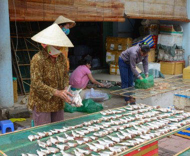 Vietnamese women making fish at market 