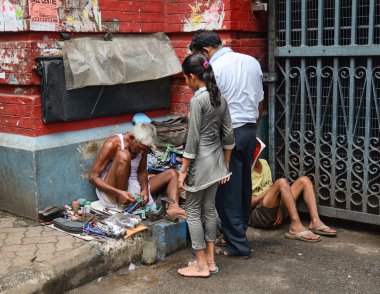 Shoe shiner does his job at street of Kolkata