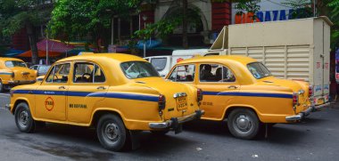 Kolkata sokakta sarı Büyükelçi taksi arabalar gitmek