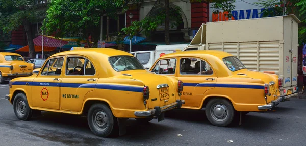 Yellow Ambassador carros de táxi ir na rua em Kolkata — Fotografia de Stock
