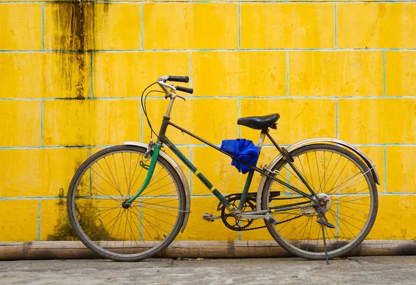 Bicicleta contra parede amarela — Fotografia de Stock