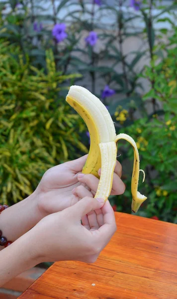 自然の背景に分離されてとられた男性の手で一口バナナ — ストック写真