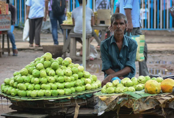 Indian men sell fruits from a stall in Delhi