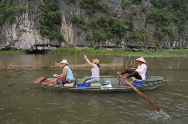 Tam Coc turist taşıyan için insanlar kürekli tekneler