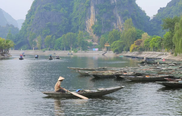 Gente botes de remos para transportar turistas en Tam Coc Imagen De Stock