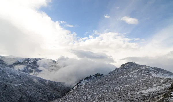 Bulutlar kar dağın üzerinden uçuyor — Stok fotoğraf