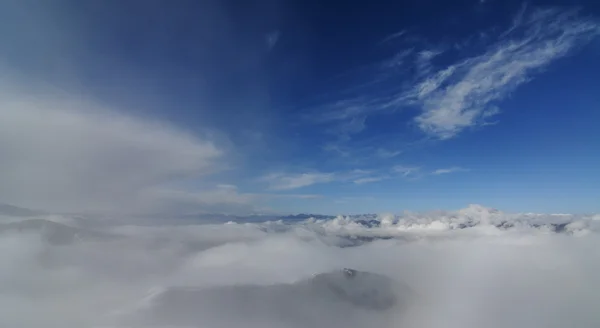 Bulutlar kar dağın üzerinden uçuyor — Stok fotoğraf